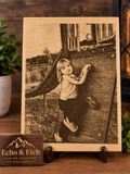 Wood photo engraving of child playing on playground slide on light wood plaque with natural grain